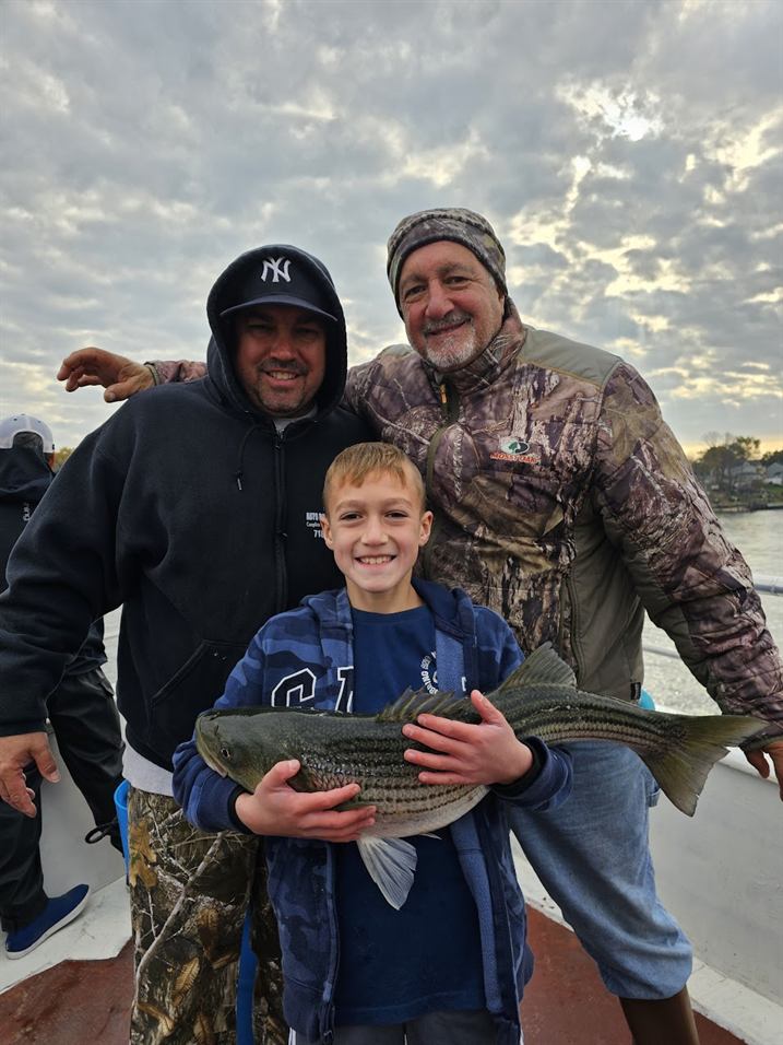 Three generations with a striped bass on deck